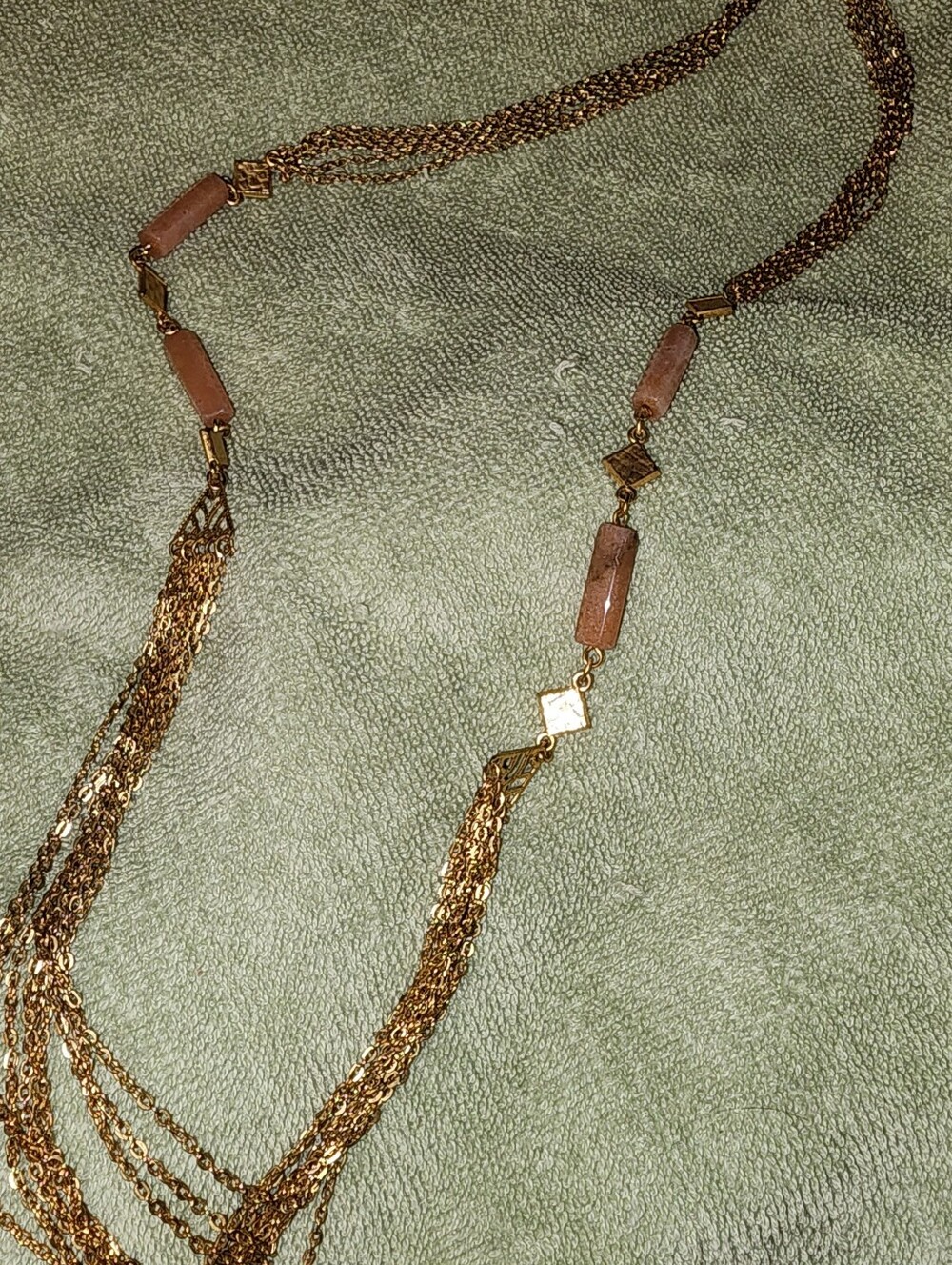multi-strand gold-tone chain necklace featuring rectangular brownish stone